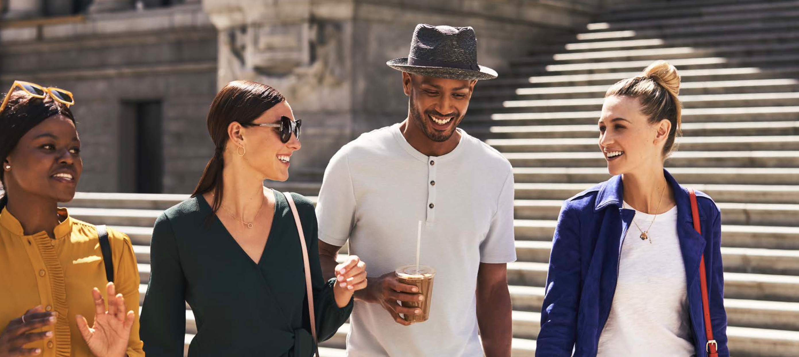 Guests walking through New York with coffee near &More by Sheraton Tribeca